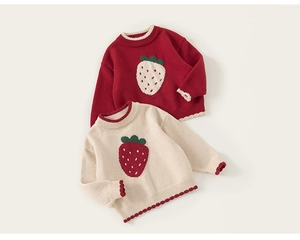 Detail of strawberry jacquard pattern and wavy ribbed edges on girls knit sweater