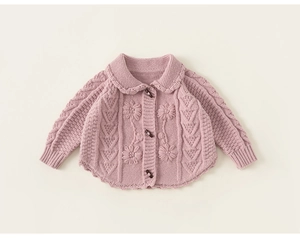 Detail of baby knit cardigan showing floral embroidery and wooden horn button closure