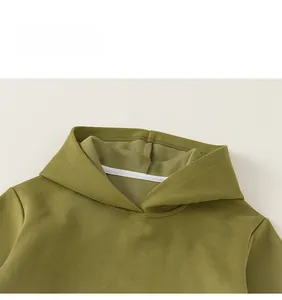 Detailansicht der weißen Stickerei auf dem olivgrünen Kapuzenpullover aus Baumwolle