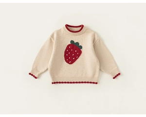 Detail of baby girl knitted sweater featuring a red strawberry motif and ruffled edges