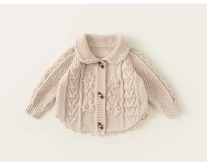Detail of baby knit cardigan with cable pattern, floral 3D decor and wooden toggle buttons