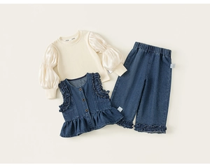Détail de l'ensemble fille en jean avec gilet en dentelle et haut blanc à manches bouffantes