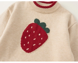 Close-up of strawberry jacquard pattern and red ribbed neckline on a knit sweater