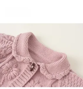 Detail of pink knit cardigan showing scalloped collar and wooden horn buttons