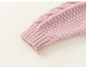 Close-up of pink knit cardigan sleeve with chunky cable pattern and ribbed cuffs