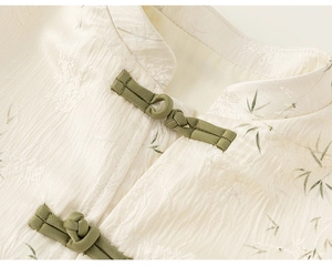 Detail of boys' Chinese style jacquard top with stand-up collar and green frog buttons