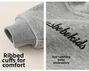 Details von Rippbündchen und feiner Buchstabenstickerei auf einem grauen Kinderhoodie