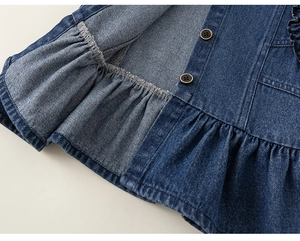 Détail d'un ensemble en jean pour filles avec ourlet à volants et boutons rétro