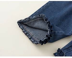 Détail du revers de jean bleu foncé avec des volants élégants et une texture en coton