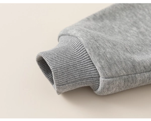 Detailaufnahme des Rippbündchens an einem melierten grauen Baumwoll-Hoodie für Kinder