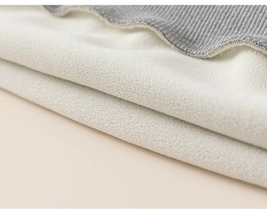 Detailaufnahme von weißem Fleece-Futter und grauem Rippstrick-Saum am Kinder-Hoodie