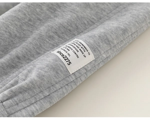 Gros plan détaillé sur le tissu en maille grise et l'étiquette tissée décorative