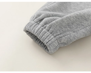 Détail d'un pantalon de jogging gris avec poignets élastiques et coutures de haute qualité