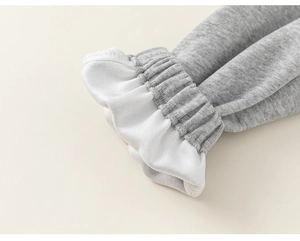 Détail du jogging gris pour fille avec ourlets élastiques à volants blancs et texture