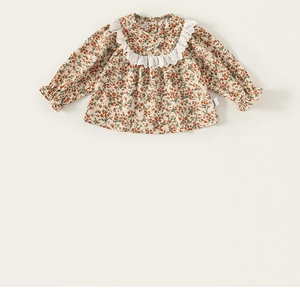 Détail du tissu en coton à fleurs avec col en dentelle blanche sur robe pour enfants