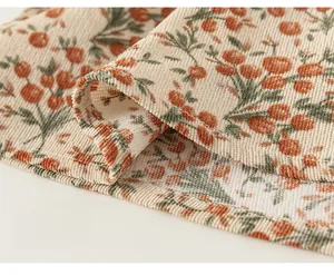 Détail du tissu en velours côtelé à motif floral avec des coutures précises et fines