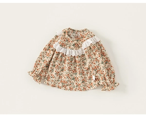 Détail de la blouse fleurie pour bébé avec col en dentelle et motif de baies