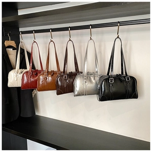 Close-up of glossy Boston bags in six colors hanging in a stylish boutique display