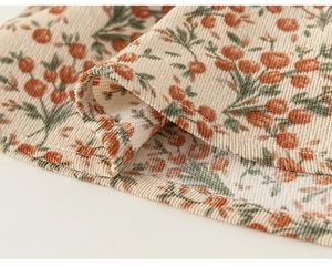 Gros plan sur la texture velours côtelé avec motifs floraux orange sur chemise