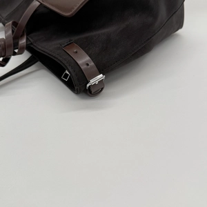 Close-up of premium dark brown leather tote bag detail with silver buckle adjustment