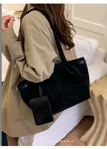 Detail of a black minimalist retro tote bag with a small detachable card pouch on a strap