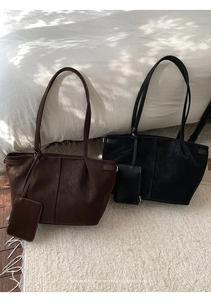 Detail of retro leather tote bag with a small matching pouch and side adjustment buckle