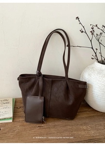 Detail of dark brown retro tote bag with small zipper pouch on a wooden stool