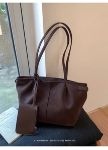 Detail view of large brown faux leather tote bag with matching zippered coin purse charm