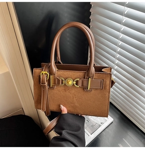 Detail view of brown leopard bag with gold heart clasp and suede-leather texture