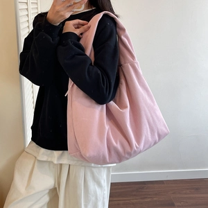 Détail du sac bandoulière en velours côtelé rose avec texture côtelée et cordon latéral