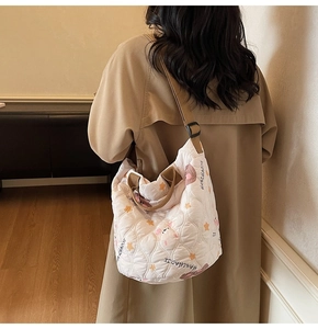 Detail view of quilted nylon tote with cute bear prints and brown shoulder straps