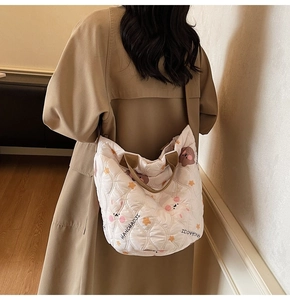 Quilted cotton tote bag with cartoon bear print and brown straps shown on shoulder