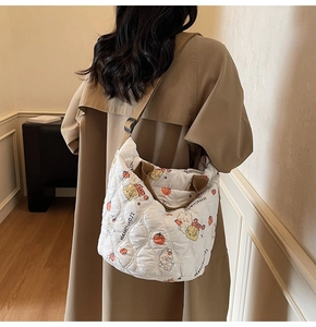 Close-up of quilted white tote bag with bear print and stylish woven brown straps