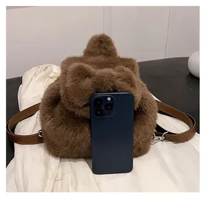 Mini brauner Plüschbär Rucksack im Größenvergleich mit Smartphone für kompakte Maße