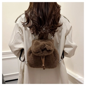 Detail des braunen Plüsch-Mini-Rucksacks mit dekorativer Schleife und Leder-Kordelzug