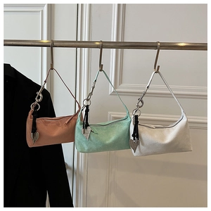Détail de sacs bandoulière oreillers minimalistes aux tons pastel avec pendentifs