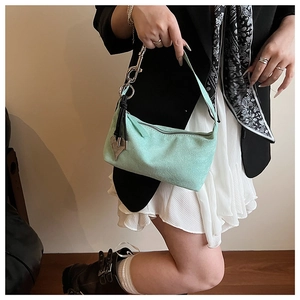 Détail du sac oreiller en daim vert menthe avec pendentif cœur argenté et anneau métal