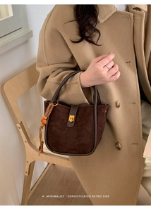 Detail der Retro-Wildleder-Eimertasche mit Goldschnalle und ethnischem Quastenanhänger