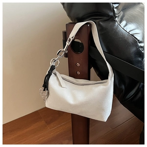 Détail du sac croissant en daim blanc avec grosse chaîne argentée et pendentif cœur