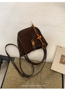 Detailansicht der Retro-Beuteltasche mit Goldverschluss und Holzperlenanhänger