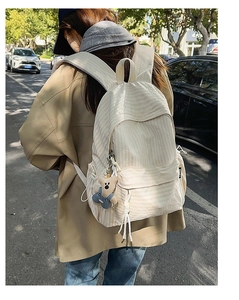 Detailed back view of beige plaid backpack with cute bear charm and side pockets