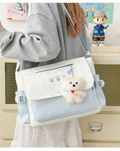 Detail shot of blue star print messenger bag with cute plush bear charm for students