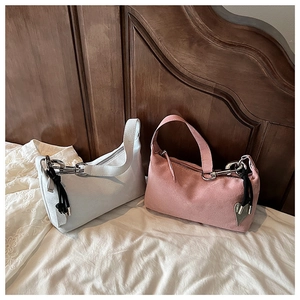 Détail de sacs oreillers en daim rose et blanc avec chaînes et breloques coeur