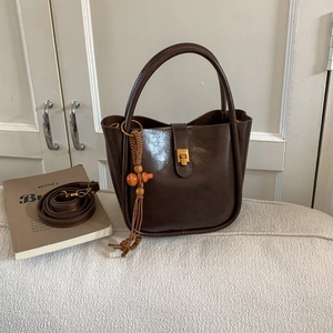 Detailansicht der dunkelbraunen Vintage-Beuteltasche mit Glanzleder und Perlenquaste