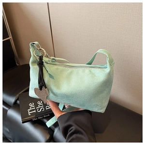 Détail du sac à main en daim vert menthe avec pendentif coeur et fermeture éclair en métal