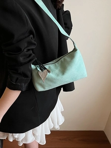 Sac oreiller minimaliste en daim vert menthe avec breloque cœur porté par mannequin