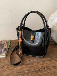 Schwarze Lacklederhandtasche im Vintage-Stil mit goldenem Verschluss und Perlenanhänger