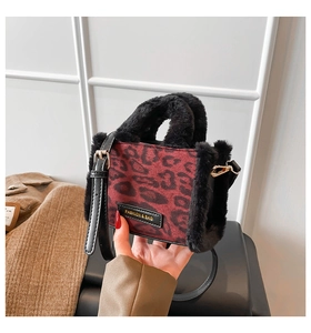 Dettaglio borsa a tracolla leopardata con bordo in ecopelliccia e stemma alla moda