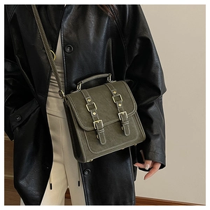 Sac messager vert armée à texture mate et boucles vintage porté par un mannequin
