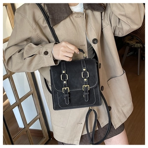 Détail d'un sac à dos en simili cuir noir avec surpiqûres et boucles dorées
